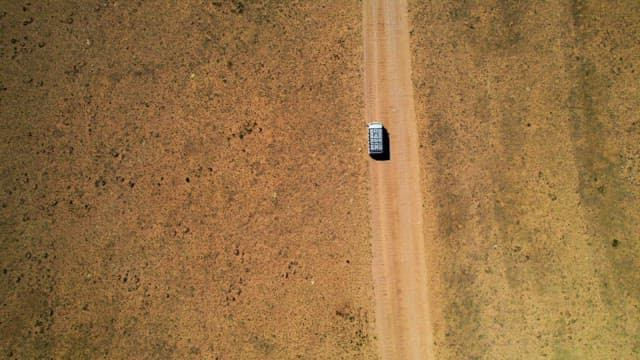 Lone Vehicle Traveling on a Desert Road