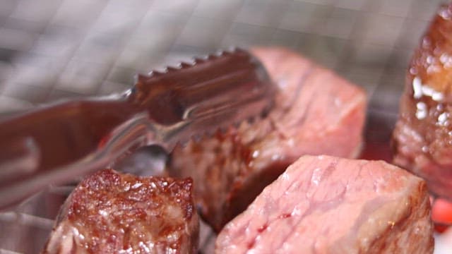 Juicy grilled meat sizzling on a barbecue