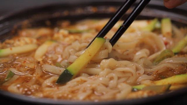 Chopstickful of spicy noodle soup from a hot pot