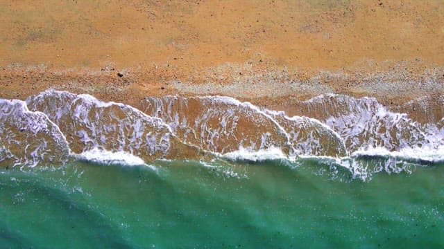 Secluded beach with emerald waves crashing in
