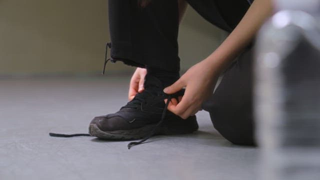 Person Tying Shoelaces Indoors
