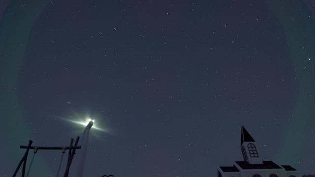 Stars and night sky movement above wind turbines
