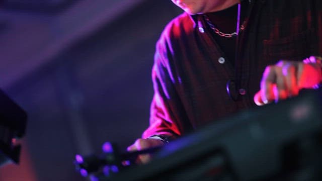 DJ Passionately Working with Turntables and Mixer