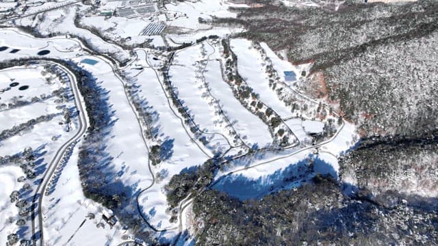 Aerial View of Snowy Landscape and Winding Roads