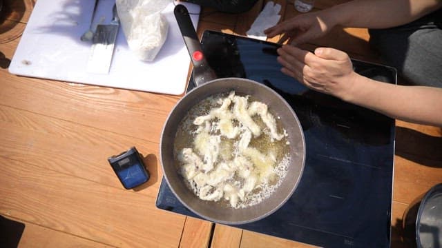 Fried webfoot octopus cooked in boiling oil in a frying pan
