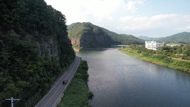 Blue river with view of road with a car running