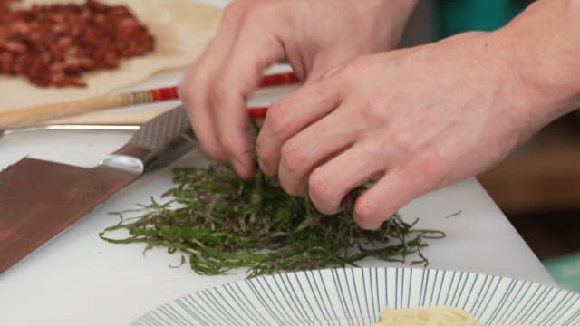 Plating well-chopped seaweed stems with pasta