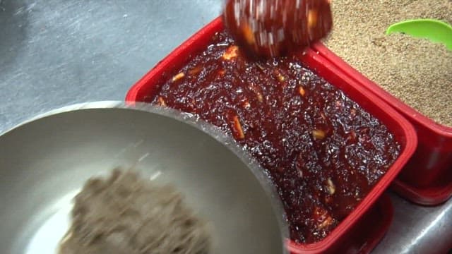 Preparing cold noodles with seasoning and sesame seeds in the restaurant kitchen