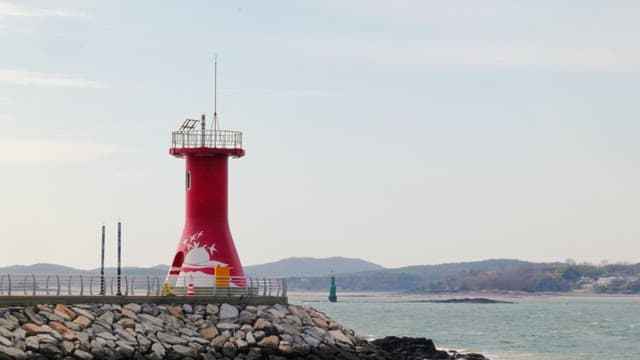 Scenery of a red lighthouse with seagulls flying