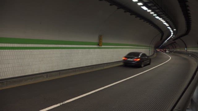 Vehicles moving through a curved tunnel