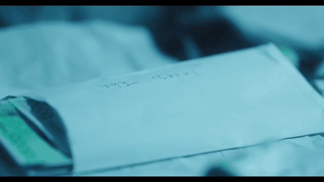 Stack of money and salary envelope on table in dark room