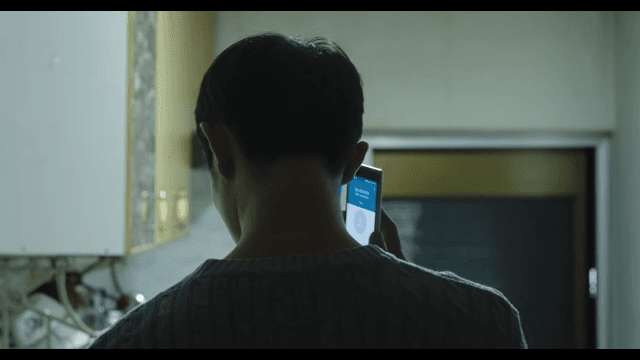Man in the kitchen alone talking on his cell phone