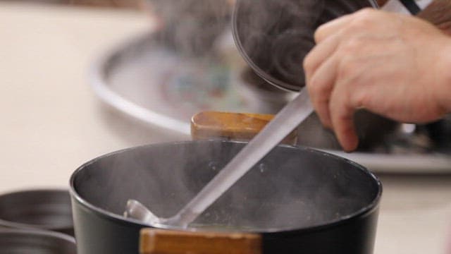 Spinach soup being ladled into a bowl