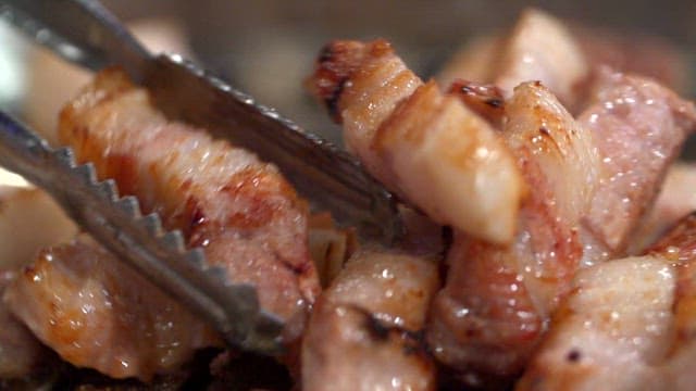 Grilled pork belly being cooked on a grill