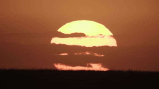 Clouds and Sun Setting Below the Meadow