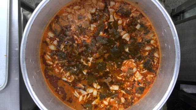 Boiling mustard leaf kimchi stew in a large pot in the kitchen
