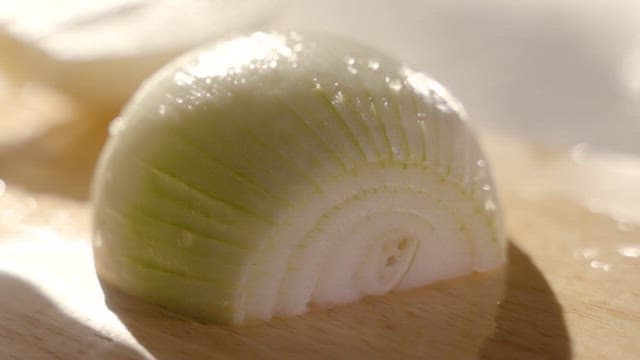 Slicing a Fresh Onion on a Wooden Board