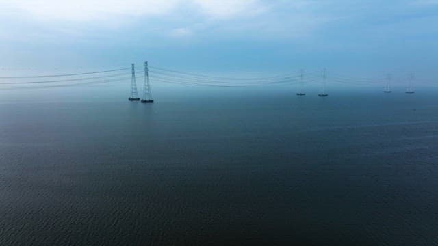 Transmission Towers and Cables over Calm Sea Waters