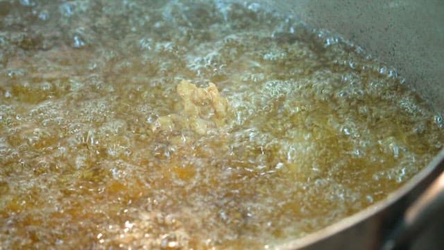 Frying food in hot oil in a pan