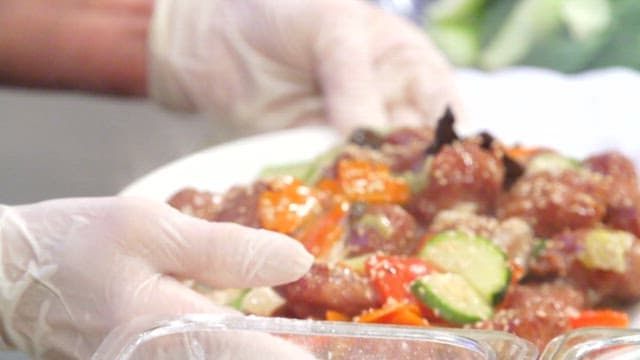 Appetizing stir-fried meatballs and vegetables sprinkled with sesame seeds served
