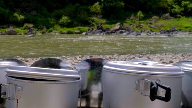Cooking pots by a flowing river