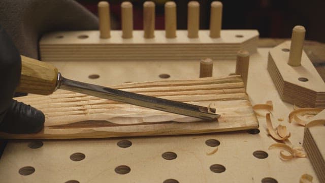 Wood carving with a chisel on a workbench