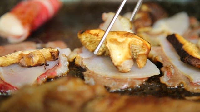 Appetizing beef brisket, mushrooms and scallops on the grill