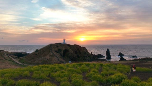 Lighthouse on a coastal cliff at sunset
