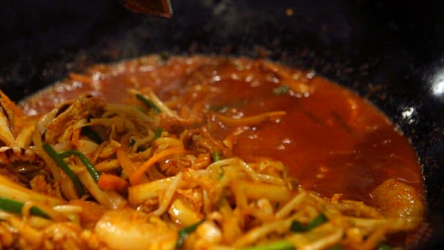 Adding noodles to the sizzling spicy jjamppong broth