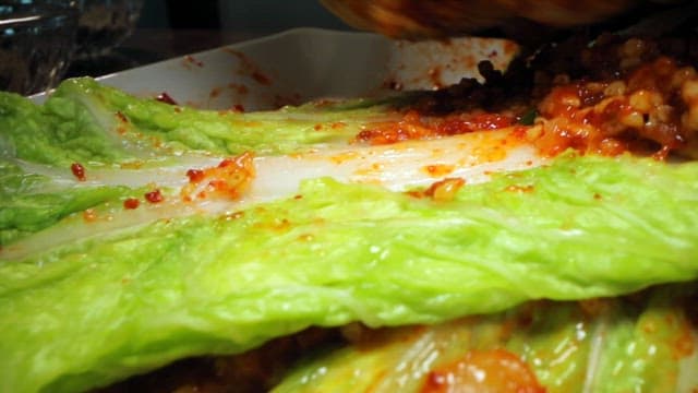 Close-up of kimchi being prepared with spices