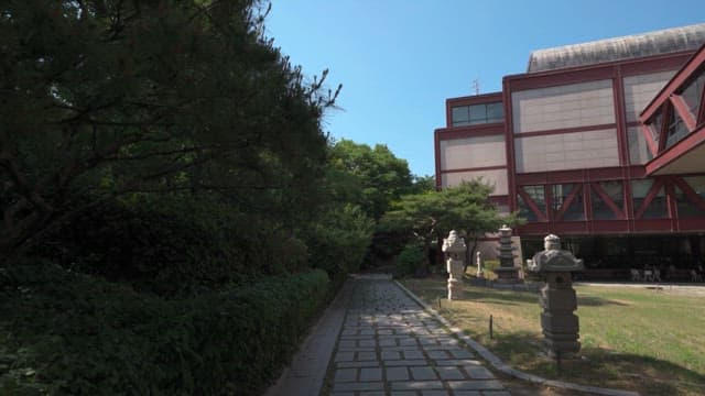 Outdoor path by a modern building with statues