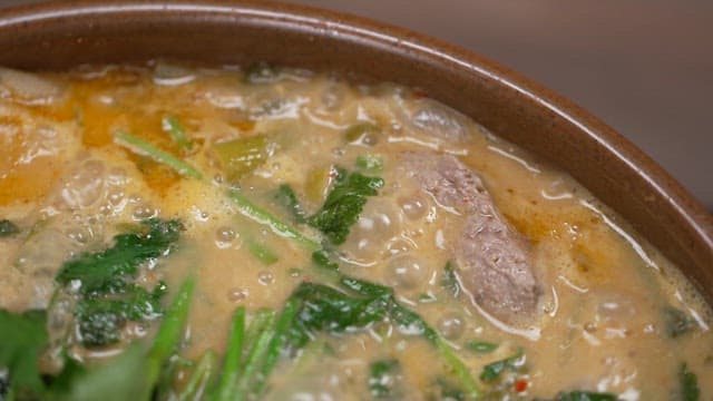 Steaming hot soup with fresh water parsley and meat