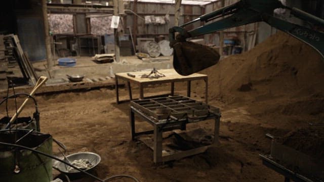 Sand being poured into a mold in a workshop