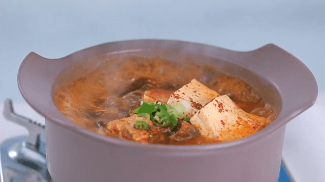 Mustard leaf kimchi stew with tofu boiling in a pot