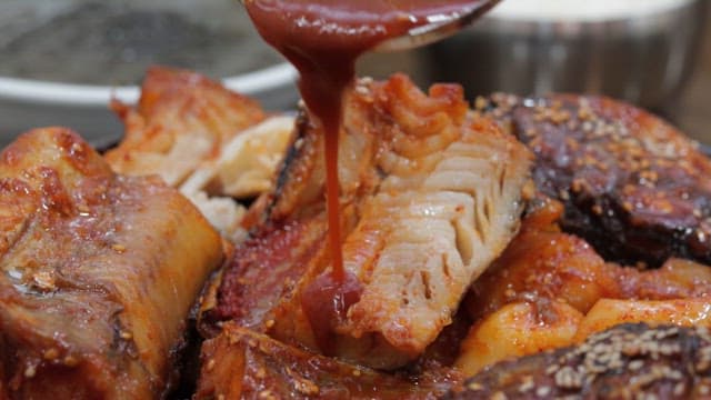 Pouring Spicy Sauce over Grilled Fish