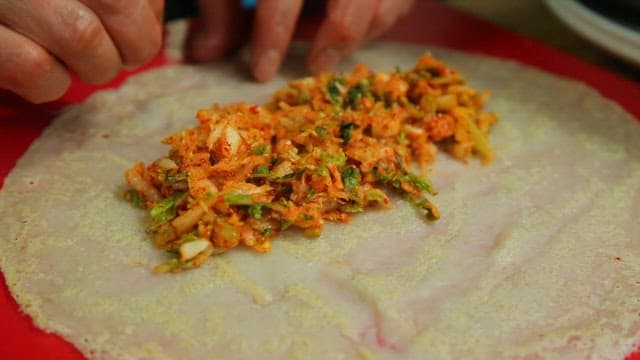Making buckwheat crepe with spicy cabbage filling