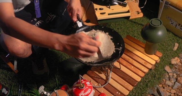 Preparing Vegetable Pancakes Outdoors at Night during Camping