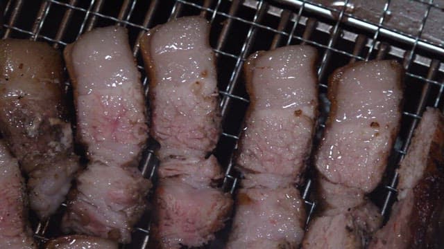 Grilling juicy pork belly slices on a barbecue grill