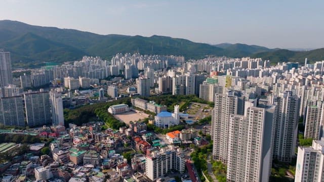 Cityscape with densely packed buildings surrounded by mountains