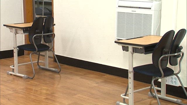 Classroom setting with empty chairs and desk
