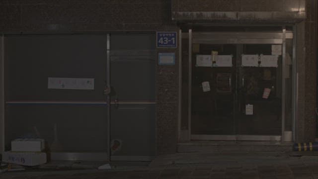 Two female students opening the front door of a building in an alley