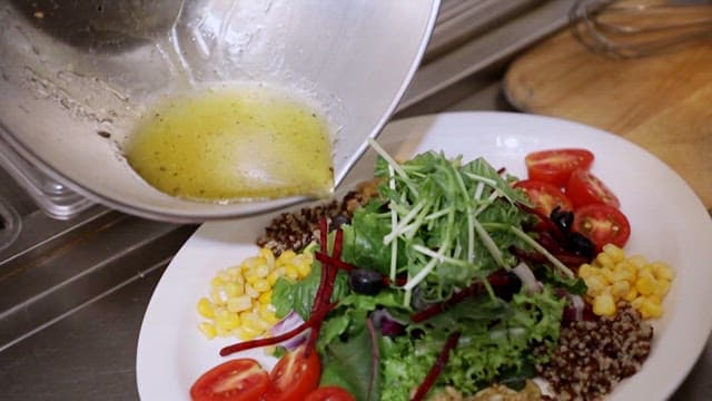 Fresh salad with dressing being poured