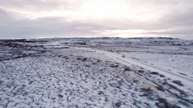 Snowy landscape with a car on a road