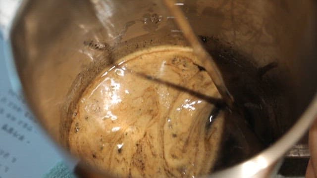 Stirring Coffee in a Stainless Steel Pot