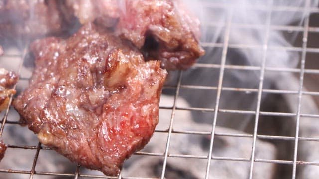 Juicy grilled meat sizzling on a barbecue