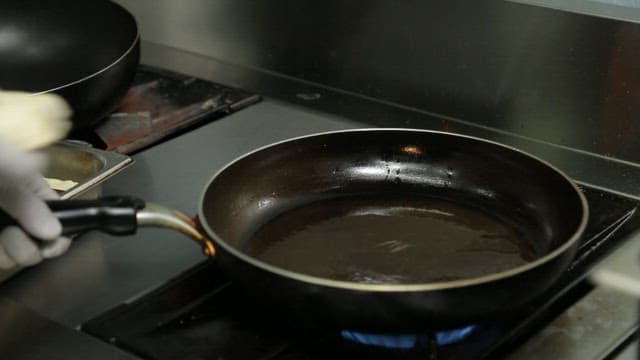 Tofu being placed and cooked in a frying pan