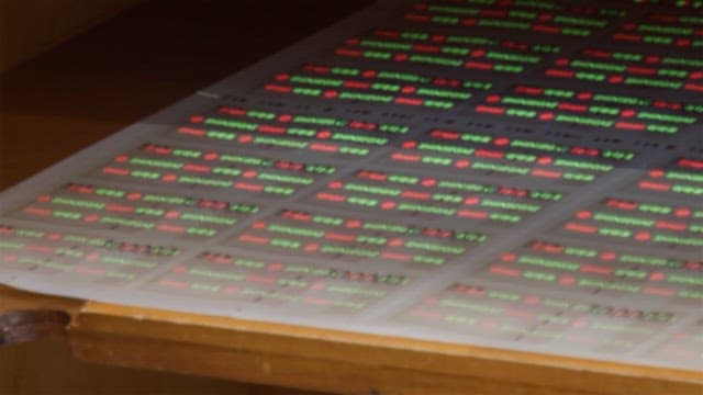 Fluorescent ink hidden in gift certificate paper under a UV lamp