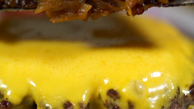 Caramelized onions topped with melted cheese and patties