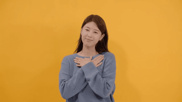 Long haired woman feeling relaxed with eyes closed and hands on chest