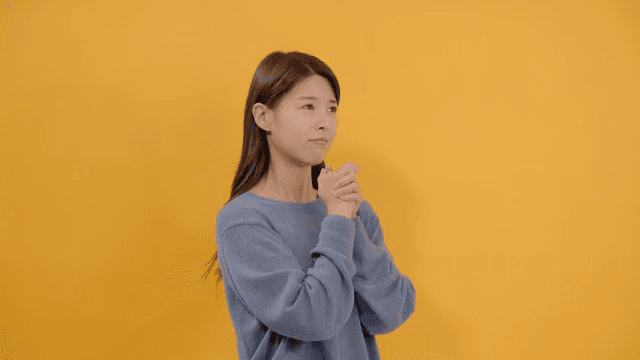 Woman praying with her hands together with a dearest expression